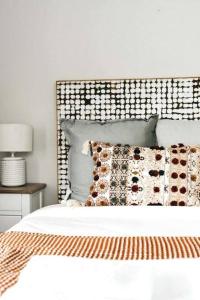 una camera da letto con un letto con testiera e cuscini di The Icely Cottage a Orange