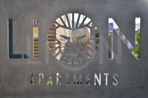 Una señal para los apartamentos americanos con una cabeza de león. en Le Lion Apartments - Bike & Ski en Aosta