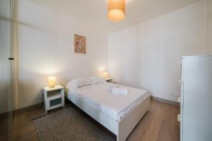 1 dormitorio con 1 cama y mesita de noche con 2 lámparas en Quiet central Lyon AIL, en Lyon