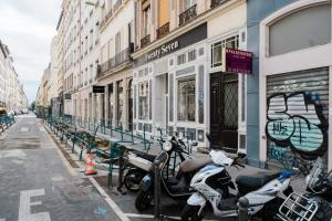 una fila de scooters estacionados al lado de una calle en Quiet central Lyon AIL, en Lyon