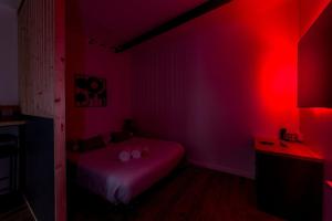 Habitación con cama y luz roja en Quiet studio Center Lyon AIL, en Gare des Brotteaux