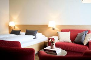 a hotel room with two beds and two chairs at Hotel Steffisalp in Warth am Arlberg