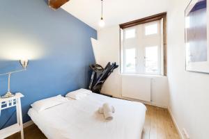 Un dormitorio con una cama blanca con un osito de peluche encima. en Grand duplex au cœur du Vieux Lyon, en Lyon 30 fotos más