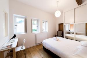 a bedroom with two beds and a desk and two windows at Large duplex in the heart of Old Lyon in Lyon