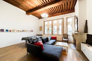 Una sala de estar con un sofá y un piano. en Grand duplex au cœur du Vieux Lyon, en Lyon