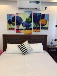 a bedroom with a bed with four paintings on the wall at Liverpool Estate - Chilaw in Chilaw