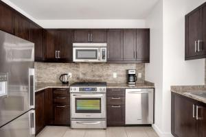 a kitchen with stainless steel appliances and wooden cabinets at Back Bay 1BR w WD Gym Roof nr Copley Sq BOS-751 in Boston