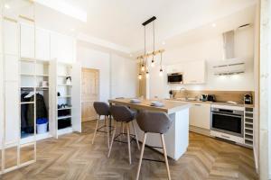 a kitchen with white cabinets and a island with bar stools at Exceptional and quiet near Part-Dieu AIL in Lyon