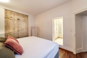 1 dormitorio con cama blanca y ventana en Haven of peace in the heart of Lyon, en Lyon