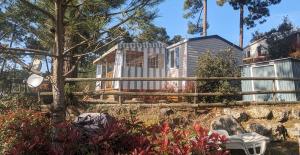 a house in a garden with a fence at Mobilhome Eleganzia 713 Bonne Anse Plage in Les Mathes