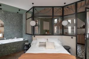 a bedroom with a large bed and a bath tub at Labolla balnéo AIL in Lyon