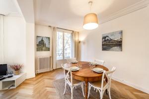 comedor con mesa de madera y sillas en Spacious and bright 70m² square AIL en Lyon