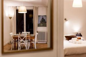 Cette chambre comprend une table, un lit et un miroir. dans l'établissement Spacious and bright 70m² square AIL, à Lyon