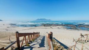 a wooden boardwalk leading to a beach with the ocean at NoulAnouk's Corner in Cape Town