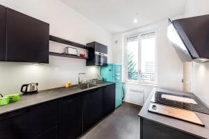 a kitchen with black cabinets and a blue refrigerator at Brand new apartment 2022 Lyon Part-Dieu AIL in Lyon