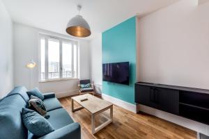 a living room with a blue couch and a tv at Brand new apartment 2022 Lyon Part-Dieu AIL in Lyon