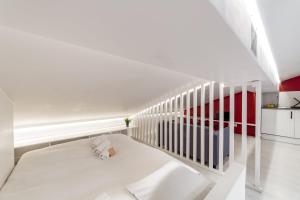 a white bedroom with a bed and a staircase at Central Studio Jacobins AIL in Lyon