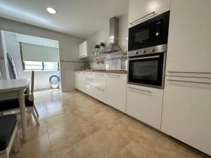 a kitchen with white appliances and a table in it at SUNRISE TERRACE in Sarria