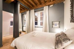 1 dormitorio con 1 cama blanca grande y 2 ventanas en Jewel apartment in Vieux Lyon AIL en Lyon