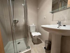 a bathroom with a toilet and a sink and a shower at SUNRISE TERRACE in Sarria