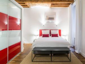 a bedroom with a white bed with red accents at Spacieux au cœur de Lyon AIL in Lyon