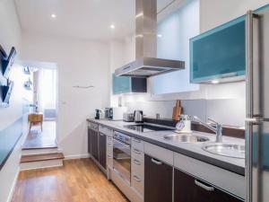 a large kitchen with a sink and a refrigerator at Spacieux au cœur de Lyon AIL in Lyon
