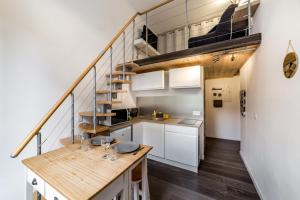 a kitchen with white cabinets and a spiral staircase at The charming studio in Croix-Rousse AIL in Lyon