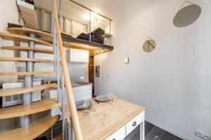 里昂的住宿－The charming studio in Croix-Rousse AIL，厨房设有木桌和螺旋楼梯。