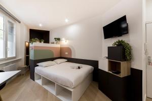 um pequeno quarto com uma cama e uma televisão de ecrã plano em Pleasant decorator's studio - Near Metro AIL em Lyon