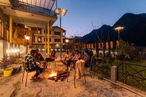 柯索的住宿－The Hosteller Kasol, Parvati Valley，一群人晚上坐在火炉旁