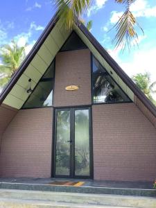a building with a large glass door and a palm tree at Liverpool Estate - Chilaw in Chilaw