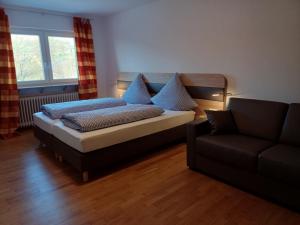 uma cama numa sala de estar com um sofá em Gasthaus Reinhardt em Alfeld
