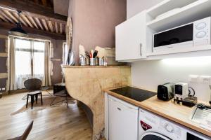 une cuisine avec des placards blancs et un comptoir dans l'établissement Authentic studio in Vieux Lyon AIL, à Lyon