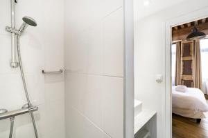 Elle comprend un lit et une salle de bains blanche pourvue d'une douche. dans l'établissement Authentic studio in Vieux Lyon AIL, à Lyon