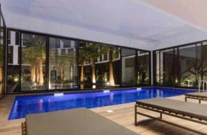 a large swimming pool in a building with windows at pool house in Douar ech Chott