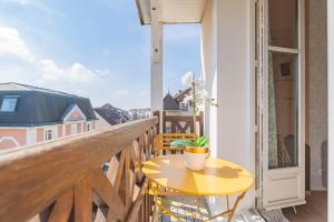a small yellow table on a balcony with a window at DISNEYLAND - WIFI - PARKING - CENTRE VILLE in Bailly-Romainvilliers