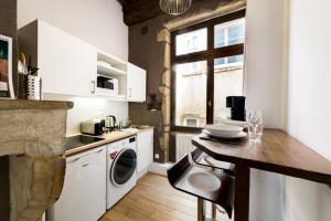 La cuisine est équipée de placards blancs, d'un évier et d'un lave-vaisselle. dans l'établissement Authentic studio in Vieux Lyon AIL, à Lyon