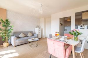 uma sala de estar com um sofá e uma mesa em DISNEYLAND - WIFI - PARKING - CENTRE VILLE em Bailly-Romainvilliers