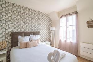 um quarto com uma cama branca e uma parede em DISNEYLAND - WIFI - PARKING - CENTRE VILLE em Bailly-Romainvilliers
