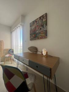 ein Wohnzimmer mit einem Schreibtisch und einem Stuhl in der Unterkunft Superbe Appartement Vue Mer T3 70m2 in Mauguio