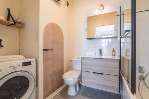 a bathroom with a toilet and a washer and dryer at DISNEYLAND - WIFI - PARKING - CENTRE VILLE in Bailly-Romainvilliers +9 photos