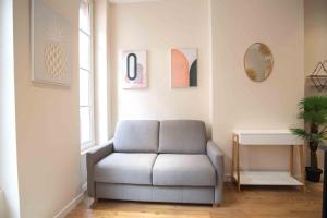 uma sala de estar com um sofá e uma mesa em Jacobin Temple Studio in the heart of Lyon AIL em Lyon
