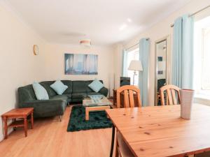 a living room with a green couch and a table at Garland in Weymouth