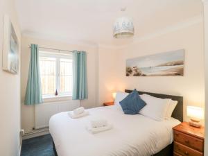 a bedroom with a large white bed and a window at Garland in Weymouth