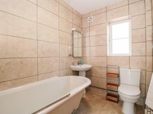 a bathroom with a tub and a toilet and a sink at Garland in Weymouth +23 photos