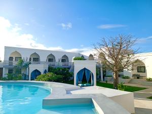 une grande piscine en face d'un bâtiment dans l'établissement Opera Hotel, à Nungwi