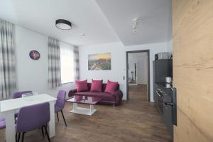 sala de estar con sofá púrpura y mesa en Ferienqaurtier- Forsthaus, en Bad Gottleuba