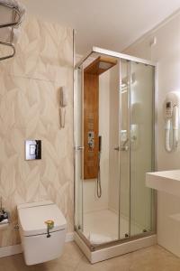 a bathroom with a shower with a toilet and a sink at Kilim Hotel Izmir in İzmir
