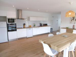 a kitchen with a wooden table and white appliances at Appartement 4 pièces 6 personnes Vue imprenable sur l'océan - Noan in Sarzeau +16 photos