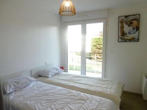 a white bedroom with a bed and a window at Appartement 4 pièces 6 personnes Vue imprenable sur l'océan - Noan in Sarzeau